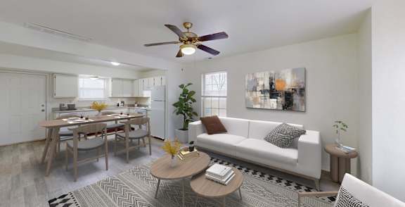 A living room with a white couch, a dining table, and a ceiling fan.