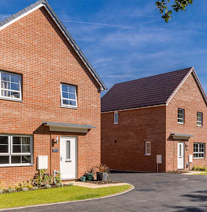A row of red brick houses with white doors and windows.