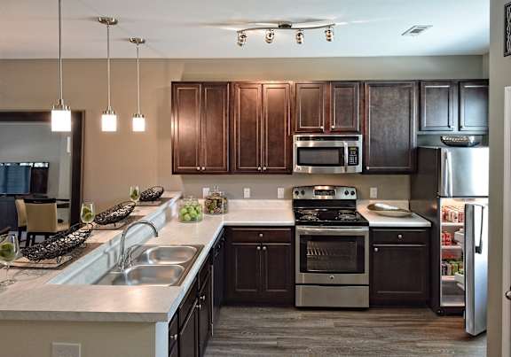 A kitchen with dark brown cabinets and stainless steel appliances.