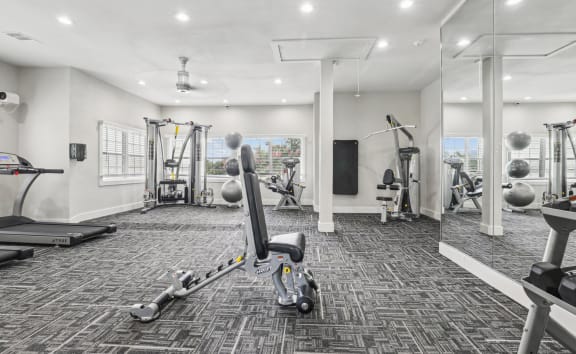 a gym with weights and cardio machines at Jefferson Creek in Irving, TX