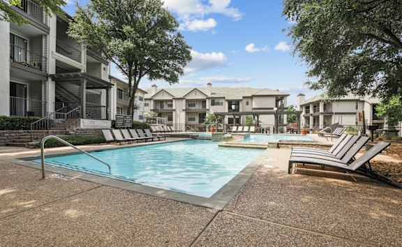 a resort style pool and lounge chairs at Jefferson Creek in Irving, TX