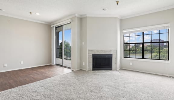 A2 floor plan living room with a fireplace and sliding glass doors that open to balcony at Jefferson Creek Apartments in Irving, TX.