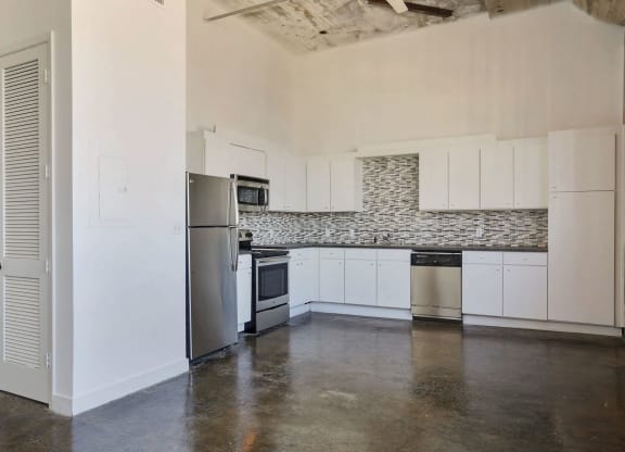 a kitchen with white cabinets and a stainless steel refrigerator