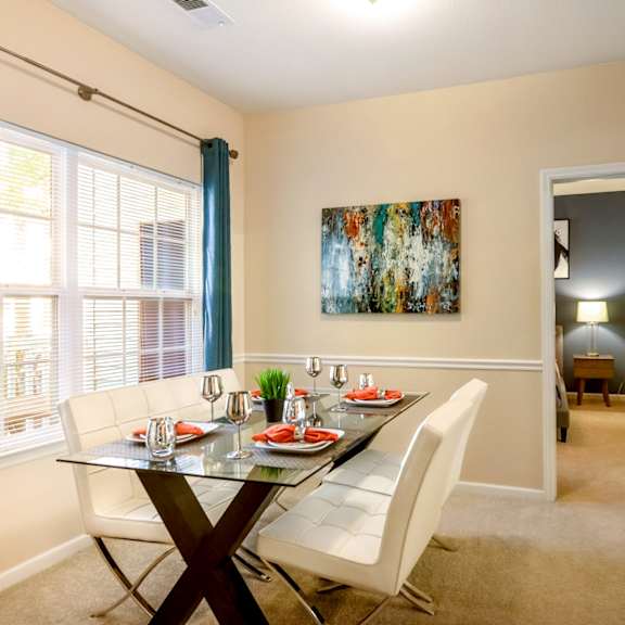A dining room with a glass table and chairs.