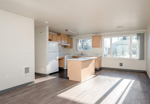 A kitchen with a white refrigerator and wooden cabinets.