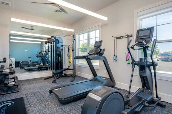 A gym with treadmills, elliptical machines, and other exercise equipment.
