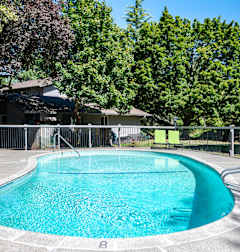 a pool with a fence around it and a house in the background