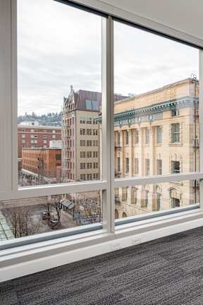 A large room with a view of a cityscape through the windows.