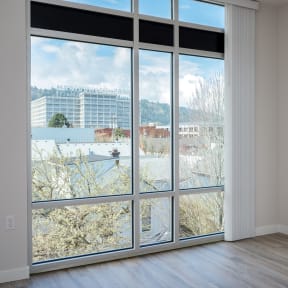 an empty room with a large window with a view of a city