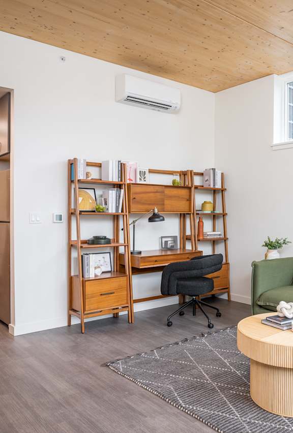 A living room with a green couch, a wooden coffee table, and a bookshelf.