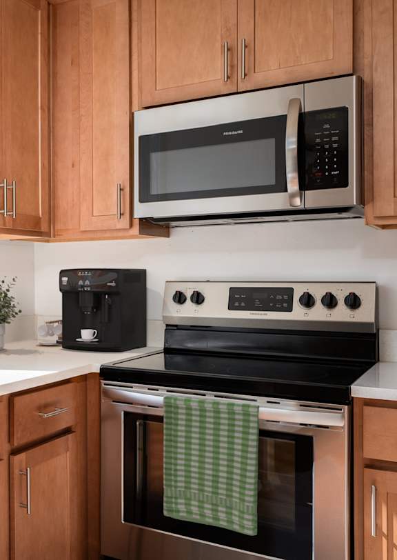 a kitchen with wooden cabinets and a stove and a window