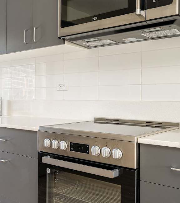 A modern kitchen with a stainless steel oven and microwave.