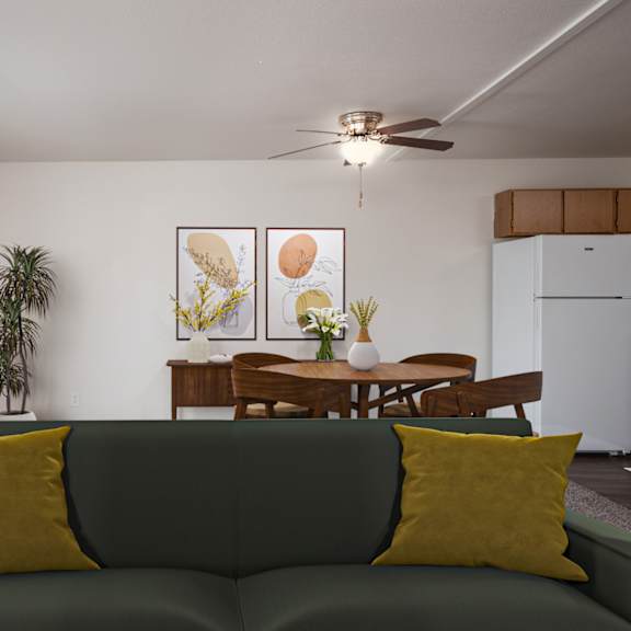 A living room with a green couch and a dining table.