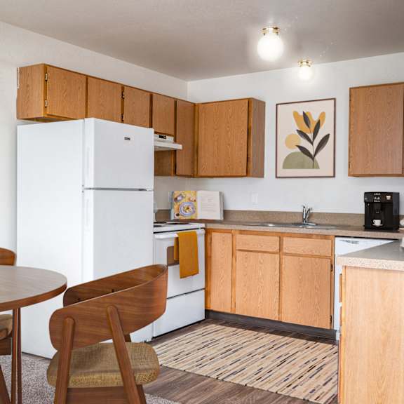 A kitchen with a white fridge and wooden cabinets.