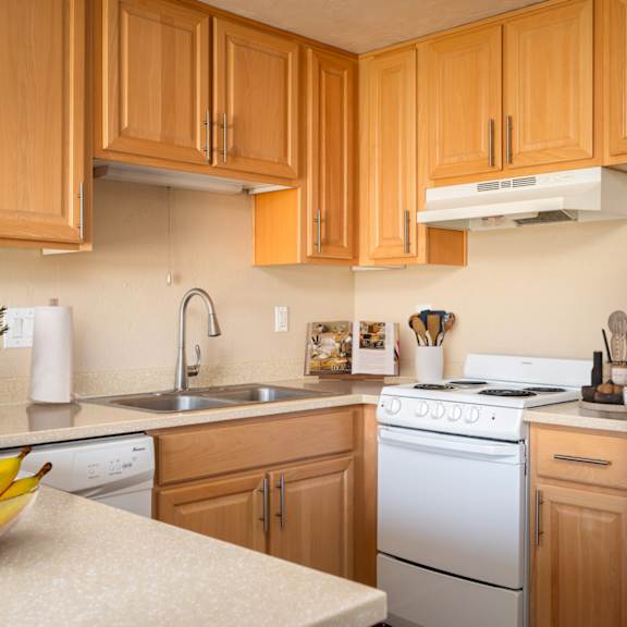 A kitchen with wooden cabinets and a white refrigerator.