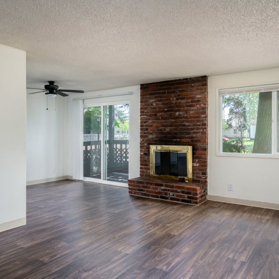 an empty living room with a fireplace and a sliding glass door