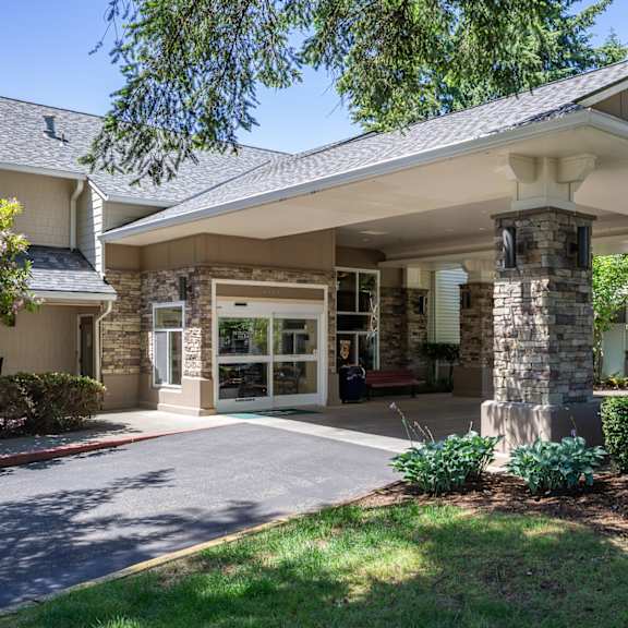 A house with a covered entrance and a stone pillar.