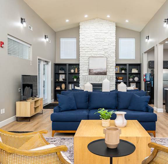 A living room with a blue couch and a fireplace.