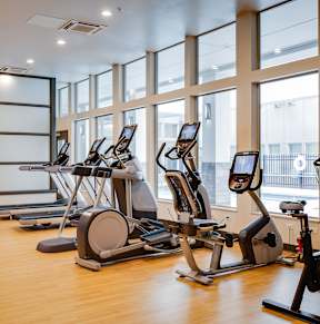 a gym full of equipment and mirrors in a luxury gym