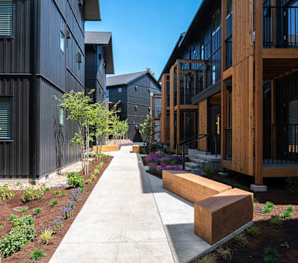 A long concrete walkway leads between two buildings.