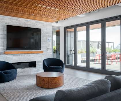 this living room has a large stone fireplace with a wooden mantle and a large flat screen tv