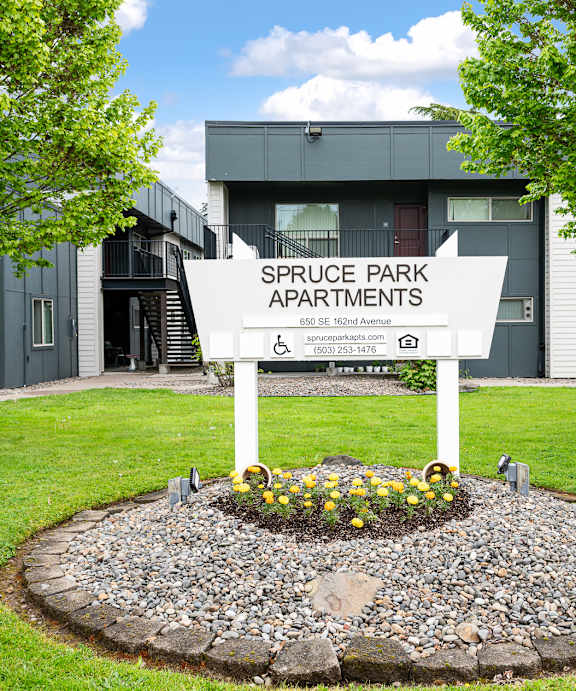 A sign for Briar Creek Apartments is surrounded by flowers.