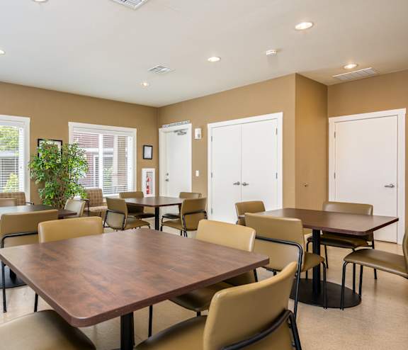 A large brown table surrounded by chairs in a room with brown walls.