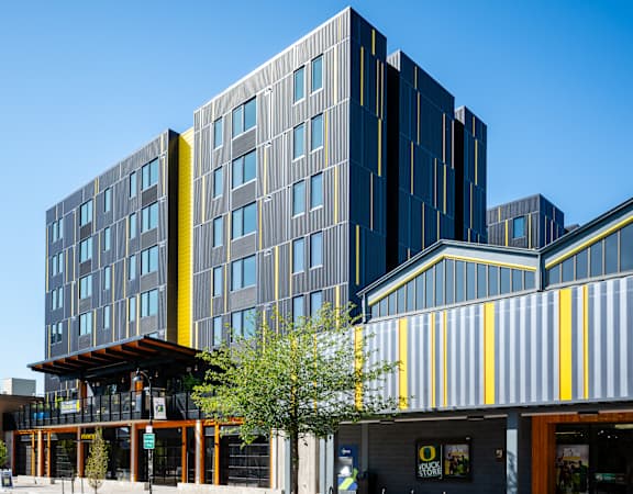 a modern building with a yellow and gray facade on a city street