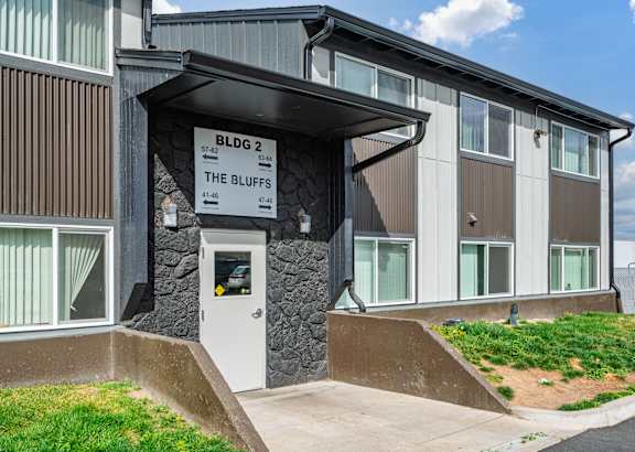 The Bluffs apartment complex has a modern design with a mix of wood and stone materials.