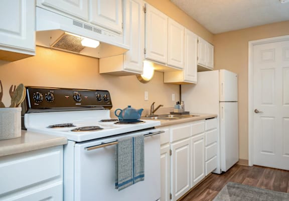 A kitchen with white cabinets and a black stove top.