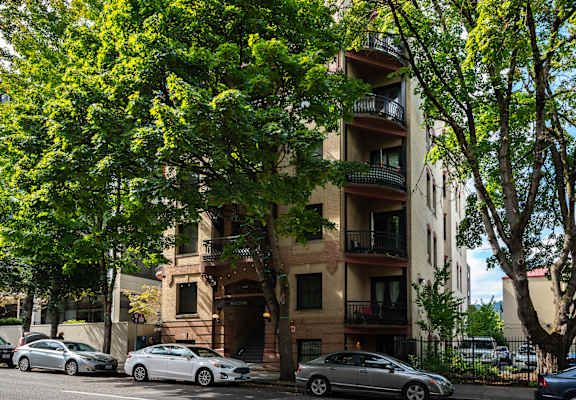 an apartment building with cars parked on the street