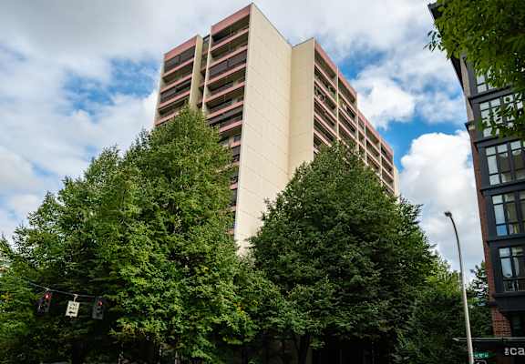 a tall building with trees in front of it