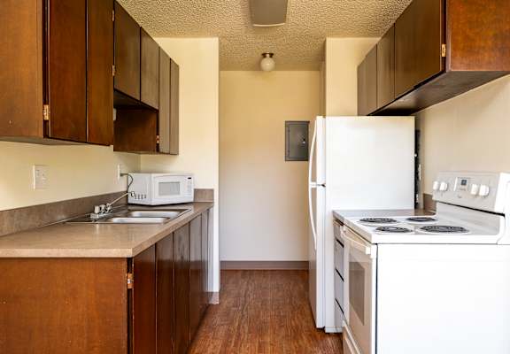 A kitchen with white appliances and wooden cabinets.