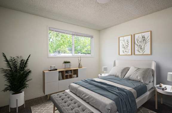 A bedroom with a bed, nightstand, and a plant.