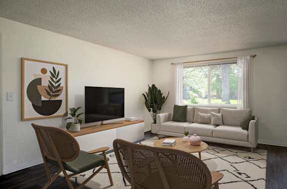 A living room with a television, couch, and chairs.