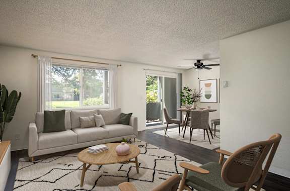 A living room with a couch, a chair, a table, and a ceiling fan.