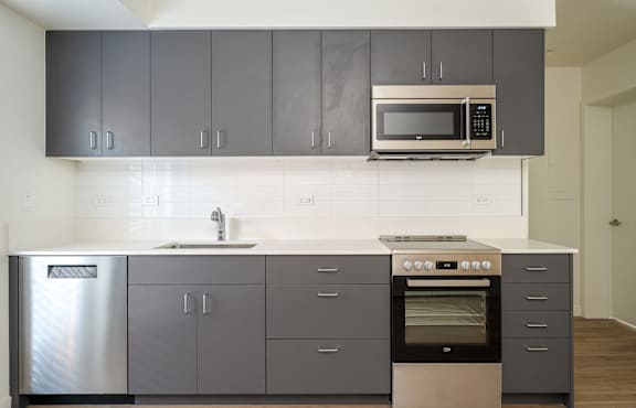 A modern kitchen with a stainless steel refrigerator, a double oven, and a microwave above the sink.