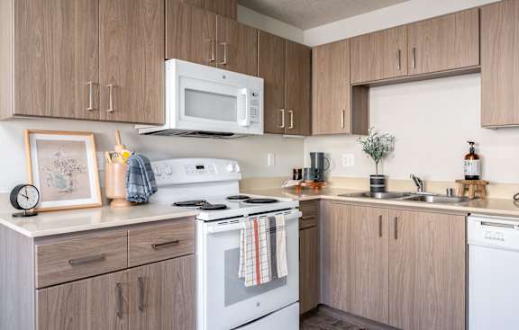 a kitchen with white appliances and wooden cabinets