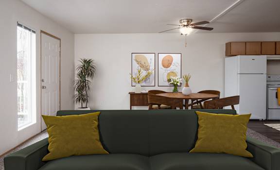 A living room with a green couch and a dining table.