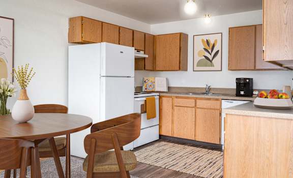 A kitchen with a white fridge and wooden cabinets.