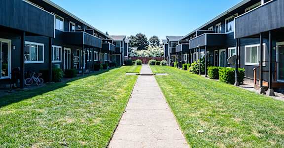 A long grassy pathway leads to a building.