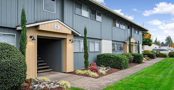 A building with a garage door entrance and a small porch area.