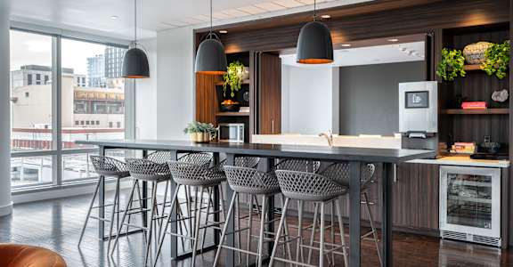 a kitchen with a large island with bar stools and chairs