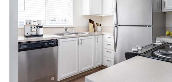 a kitchen with white cabinets and stainless steel appliances