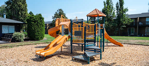A playground with a yellow slide and a green and yellow play structure.