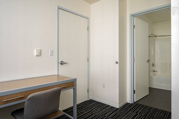 A room with a desk and chair in it.