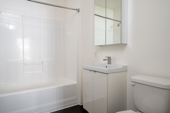 A white bathroom with a sink, toilet, and bathtub.