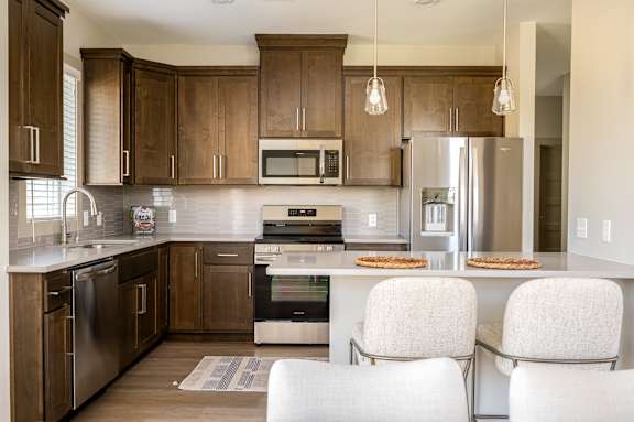 A modern kitchen with wooden cabinets and stainless steel appliances.