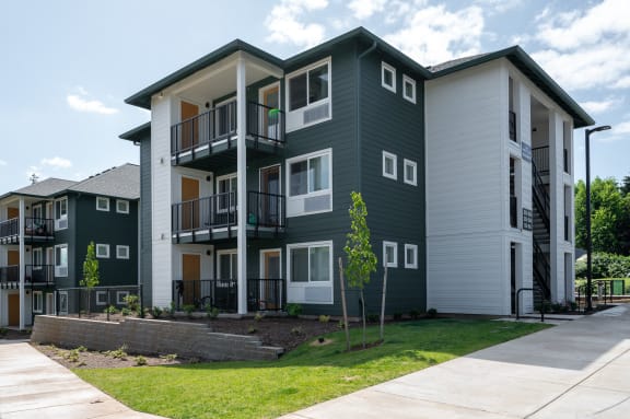 an exterior view of an apartment building with green and white walls