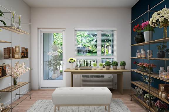 a living room with a table and plants and a window
